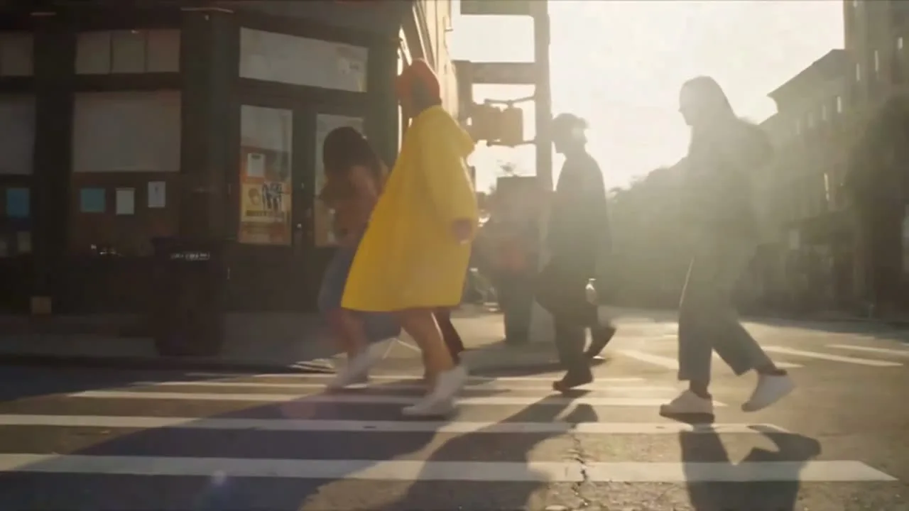 After: the same frame with the same people in the same positions, her coat now a bright yellow raincoat